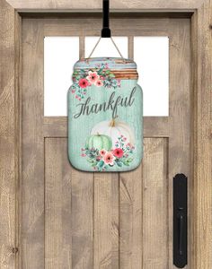 a wooden door with a painted mason jar hanging from it's side and the words, thank you