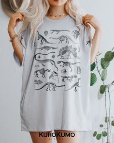 This Unisex t-shirt features a vintage set of dinosaur skeletons and fossils. It is perfect to style with different kinds of alternative fashion like goblincore, grunge, dark academia, & more. Manifest the inner paleontologist in you with this sweatshirt! >> Also available in: - Crewneck --> https://www.etsy.com/listing/1118732683 ABOUT - It is made to order using direct to garment printing. - Runs true to size with a retail fit or size up for an oversized fit. Please refer to size Casual Cotton T-shirt With Dinosaur Print, Unisex Dinosaur Print Crew Neck Top, Graphic Tee With Dinosaur Print For Summer, Dinosaur Print Graphic Tee For Summer, Casual Unisex Dinosaur Print Tops, Cotton Short Sleeve Shirt With Dinosaur Print, Summer Dinosaur Print Graphic Tee, Summer Dinosaur Print Shirt With Crew Neck, Relaxed Fit Dinosaur Print Crew Neck Tops