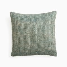 a green and white pillow sitting on top of a white wall