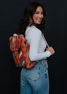 Orange with teal, brown, lilac, cream and black Aztec inspired backpack Clasp closure on the front Adjustable straps and handle Measures 14" x 11.5" x 4.5" 100% Cotton Lining: 100% Polyester Trendy Brown Tote Backpack, Brown Adjustable Backpack For Everyday Use, Adjustable Brown Backpack For Everyday Use, Brown On-the-go Bags With Adjustable Straps, Multicolor Everyday Backpack With Adjustable Straps, Multicolor Backpack With Adjustable Straps For Everyday Use, Everyday Multicolor Backpack With Adjustable Strap, Brown Bohemian School Bags, Bohemian Style Brown Backpack