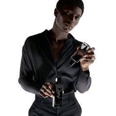 a man is holding an electronic device in one hand and looking at the camera with his other hand