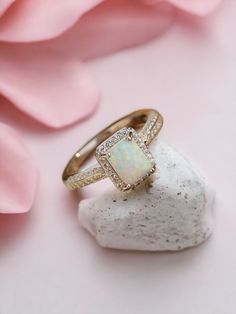 Indulge in the timeless elegance of our S925 Sterling Silver Square White Opal Ring. This exquisite piece features a captivating white opal set in a vintage-inspired design, complemented by sparkling zircon stones. Perfect for weddings, engagements, or adding a touch of fantasy to your everyday style, this ring is a must-have for any jewelry collection. Specifications:  Main Stone: White Opal Side Stones: Zircon Material: S925 Sterling Silver Shape/Pattern: Rectangle Style: Vintage Ring Type: We Elegant Opal Jewelry With Halo Setting, Classic Moonstone Opal Ring For Anniversary, Classic Opal Moonstone Anniversary Ring, Elegant Opal Ring With Diamond Accents, Elegant Opal Ring With Center Stone, Classic Opal Anniversary Ring, Opal Ring With Diamond Accents For Gift, Elegant Opal Jewelry With Halo Design, Gift Opal Ring With Diamond Accents