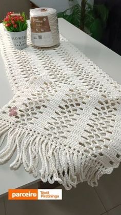 the table is covered with white crocheted doily next to a potted plant