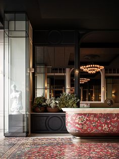 a bath tub sitting in the middle of a room next to a tall glass window