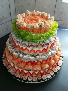 there is a very large cake made out of sushi and lettuce on top