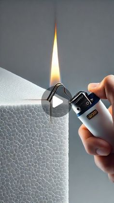 a person lighting a lighter on top of a piece of white paper with a flame