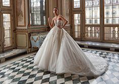 a woman in a wedding dress standing on a checkered floor with windows behind her