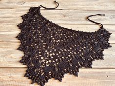 a black crocheted top sitting on top of a wooden table