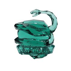 a green glass sculpture sitting on top of a table