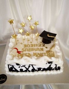 a white cake with gold stars and a graduation cap on top