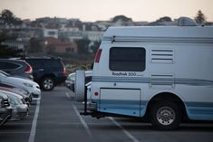 an rv parked in a parking lot next to other cars