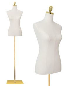 two white mannequins are standing on gold bases