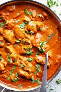 a pan filled with chicken curry and garnished with cilantro