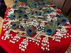 a red table topped with lots of peacock brooches and white pearls on top of it