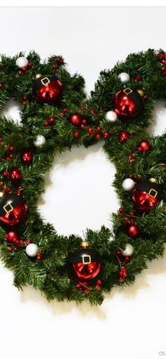 a mickey mouse christmas wreath with red and white ornaments on it's center piece