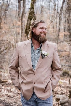 a man with a beard wearing a tan suit