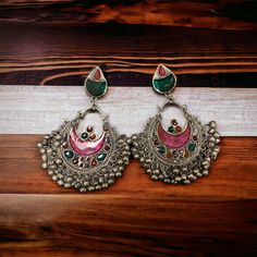 The Pink Gul Chandbali Earrings features intricate flower and peacock design on Oxidized Silver with multicolor crystals. The addition of ghungroos completes the look of this chandbali. Specifications Materials used: Oxidized Silver, Meenakari, Ghungroos At Romikas, we pride ourselves on the craftsmanship and high quality of our jewelry, designed to enhance your natural beauty. Please contact us with any questions. Luxury Ornate Meenakari Earrings, Luxury Round Meenakari Earrings, Luxury Meenakari Chandelier Earrings For Diwali, Traditional Multicolor Chandbali Hoop Earrings, Multicolor Chandbali Earrings With Intricate Design, Multicolor Traditional Hoop Earrings With Latkans, Traditional Multicolor Hoop Earrings With Latkans, Traditional Multicolor Oxidized Earrings, Traditional Multicolor Festive Hoop Earrings