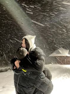 a man and child are hugging in the snow