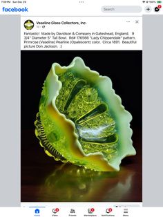 a green glass bowl sitting on top of a table next to a facebook page with the caption'vase glass collectors, inc '