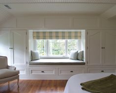 a bedroom with a window seat and built in bookshelves