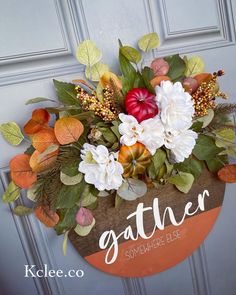 a sign that says gather with flowers and leaves on the side of a building door