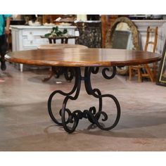 a wooden table sitting on top of a floor next to other tables and chairs in a room