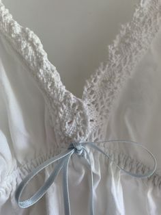 This adorable cotton babydoll top by Victoria's Secret is pure white with light blue now trim and crochet detail!  Super cute as a top over jeans or as a nightgown top or short chemise.  Elastic at back for fit - front has triangle cups and V neck bodice  Straps adjust Tagged size small  Bust flat at back is 12 inches stretching out to 18 inches at the back.  Length as shown is 28 inches  Super comfy for hot weather and summer nights Straps are faintly yellowing. No other issues.  Final sale. No Baby Doll Top, Women's Nightgowns, Babydoll Top, Nightgowns, Cotton Crochet, Crochet Details, Hot Weather, Small Bust, Low Back