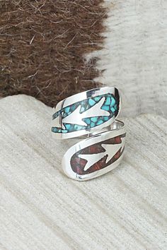 This turquoise, coral chip inlay and sterling silver ring was made by Navajo silversmith Jolene Yazzie. The inside is stamped sterling.Size: 7.5Length: 1"Free shipping on all orders! We ship with USPS and always include tracking. All orders ship within a day of payment.Returns are accepted up to 30 days after you receive your order. Just send us a message. Our shop offers cash back or store credit. The item must be returned in new condition. Artisan Turquoise Inlay Ring As A Gift, Artisan Turquoise Inlay Ring As Gift, Artisan Turquoise Inlay Ring For Gift, Artisan Turquoise Ring With Inlay, Turquoise Inlay Rings As A Gift, Southwestern Style Rings With Inlay As Gift, Artisan Adjustable Turquoise Ring With Inlay, Southwestern Style Rings With Inlay For Gift, Adjustable Turquoise Ring With Inlay For Gift