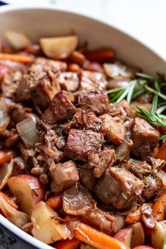 a bowl filled with meat and vegetables on top of a table