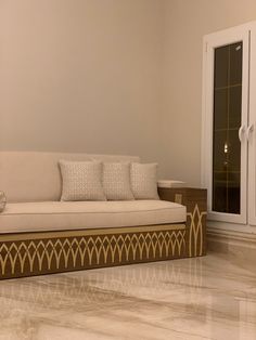 a white couch sitting on top of a hard wood floor next to a glass door