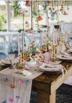 the table is set with flowers and candles