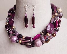 Make a real statement with this colorful necklace set. Glass lamp work beads, seed beads, freshwater pearls, Swarovski crystals, and resin beads in hues of mauve, burgandy,  purple, lavender, and gold are strung onto 4 wires.  I finished the design with decorative silver bead caps and a large lobster clasp.  The necklace measures 20 inches long.  Matching beaded drop earrings are hung on 925 silver ear wires. Unique Multi-strand Jewelry With Spacer Beads, Costume Jewelry With Polished Multi-strand Beads, Costume Jewelry With Large Beads And Multi-strand, Multi-strand Large Bead Party Jewelry, Elegant Multi-strand Czech Glass Necklaces, Elegant Multi-strand Czech Glass Jewelry, Multi-strand Czech Glass Colorful Beads Jewelry, Colorful Multi-strand Czech Glass Beaded Jewelry, Multi-strand Czech Glass Jewelry With Gemstone Beads