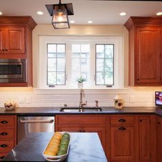 a kitchen with wooden cabinets and black counter tops