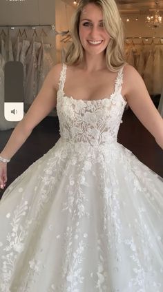 a woman standing in front of a dress on display