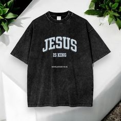 - Premium Comfort: Made from high-quality, soft cotton for all-day wearability and a comfortable fit. - Vintage Appeal: Features a distinctive vintage wash that offers a classic, worn-in look for a touch of retro style. - Faithful Message: Boldly displays "Jesus is King" to express your devotion and share your faith with those around you. - Versatile Wear: Perfect for casual outings, relaxed gatherings, or simply lounging at home, combining both style and comfort. - Durable Design: Crafted to wi Washed Black Cotton T-shirt With Letter Print, Vintage Cotton Shirt With Letter Print, Oversized Vintage Shirt With Letter Print, Washed Cotton Shirt For Streetwear, Jesus Is King Shirt, Jesus Is King, King Shirt, Christian Shirt, Jesus Is