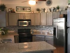 a kitchen with stainless steel appliances and granite counter tops, along with an island in the middle