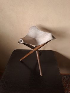 a white chair sitting on top of a wooden table next to a brown and tan wall