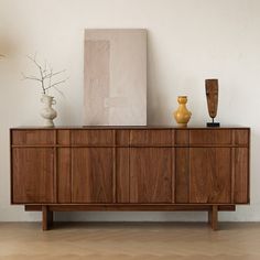 a wooden cabinet with vases on top of it