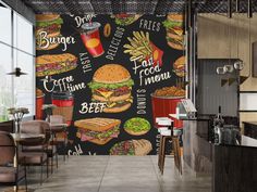 a restaurant wall mural with burgers and fries on it's black back drop