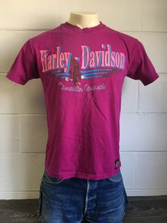 Harley Davidson 1988 Tshirt. The magenta tee gives the whole piece some lovely flair. SWEET graphics on both sides, and a Harley tag sewn at the bottom hem. There is some general light wear/fading and a separation at the collar (see pics) but no holes and overall excellent condition. Check out other SWEET Harley tees in my shop https://www.etsy.com/shop/sweetVTGtshirt?section_id=11916604&ref=shopsection_leftnav_8 Dimensions: Inches CHEST: 20 1/2 Bottom Hem: 20 1/2 Shoulder to shoulder: 17 1/ Retro Purple Short Sleeve Top, Retro Purple Tops For Streetwear, Retro Pink T-shirt For Streetwear, Vintage Purple Graphic Print Top, Retro Purple Tops With Graphic Print, Purple Retro Tops With Graphic Print, Vintage Purple T-shirt With Letter Print, Retro Pink T-shirt With Screen Print, Retro Purple Crew Neck Top