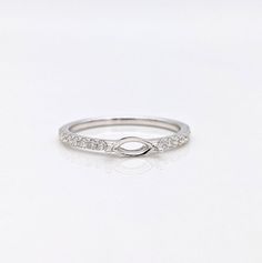 a white gold ring with diamonds on the sides and an oval design in the middle