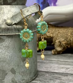 Handmade Cheerful Aqua Sunflower Bead Earrings 0924-e72 Elevate your accessory game with these stunning handmade earrings! Featuring vibrant aqua czech glass sunflower beads beautifully paired with cheerful green square beads and tiny beige accent beads delicately wire wrapped. Brighten your day and your look with these enchanting earrings. Perfect as a special treat for yourself or a thoughtful gift for someone you cherish!  Materials: Aqua sunflower beads, cheerful green square beads, tiny beige beads, & nicklefree earwire Drop length: just a touch shorter than 2.25 inches  Colors: Aqua, cheerful green, and beige  Shipping: ships from a pet-friendly and smoke-free home in Waco, TX  Add a splash of color and creativity to your collection--add these beautiful earrings to your cart now! Handmade Bohemian Flower Earrings With Czech Glass, Bohemian Czech Glass Dangle Flower Earrings, Bohemian Green Flower Earrings With Round Beads, Handmade Czech Glass Flower Dangle Earrings, Turquoise Czech Glass Dangle Jewelry, Green Czech Glass Flower Earrings, Green Dangle Earrings With Spacer Beads, Turquoise Round Beaded Earrings, Turquoise Czech Glass Round Bead Earrings