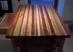 a wooden table top sitting in the middle of a kitchen