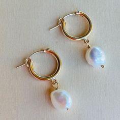 Lanai Pearl and Small Hoop Earrings. Inspired by the simple beauty of pearls, this earring showcases an asymmetrical pearl paired with a shinny golden hoop, creating a classic and feminine earring perfect for day- and night- wear.    14Kt Gold Filled hoop   White Potato Peal Pearl  Approx. 1.5" long  Made in USA Small Hoop Pearl Earrings, Everyday Pearl Chain Hoop Earrings, Small Hoop Earrings With Pearl Charm, Hoop Pearl Earrings With Pearl Pendant, Small Hoop Pearl Drop Earrings, Pearl Pendant Hoop Earrings, Modern Small Hoop Pearl Drop Earrings, Hoop Pearl Chain Earrings, Modern Hoop Earrings With Pearl Charm