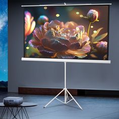 a large projection screen on a stand in front of a wall with flowers and stars