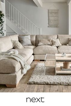 a living room filled with furniture and a stair case next to a coffee table on top of a rug