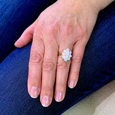 a woman's hand with a flower ring on it