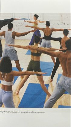 a group of people doing yoga on mats in front of the ocean with their arms stretched out