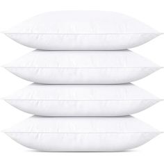 four white pillows stacked on top of each other in front of a white background,