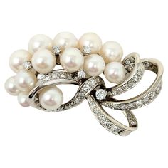 Exquisite vintage style brooch with incredible fine details. This gorgeous brooch is made of 14 karat white gold and arranged in a horizontal layout. The top portion features 2 rows of white cultured pearls, accented by a few single round diamonds. The pearls have a high luster with a lovely rose overtone. The bottom portion is mainly all pave diamonds set in white gold and arranged in a swirling ribbon design. The single cut diamonds are G-H in color, VS-SI in clarity and total 1.70 carats. The Exquisite Diamond Accented Brooches For Wedding, Classic Platinum Brooches, Exquisite Wedding Brooches With Diamond Accents, White Diamond Wedding Brooches, Exquisite White Wedding Brooches, Classic Platinum Brooch With Brilliant Cut, Classic White Diamond Brooches, Luxury Diamond White Brooches For Wedding, Fine Jewelry Wedding Brooches With Diamond Accents